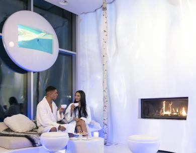 Relaxed couple in modern spa with fireplace.