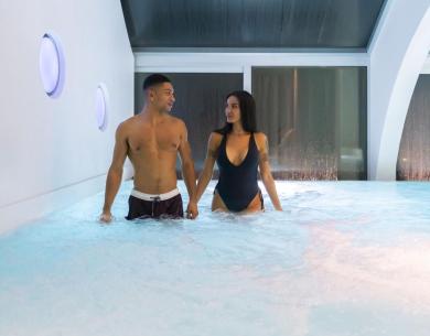 Couple dans une piscine intérieure, ambiance relaxante.