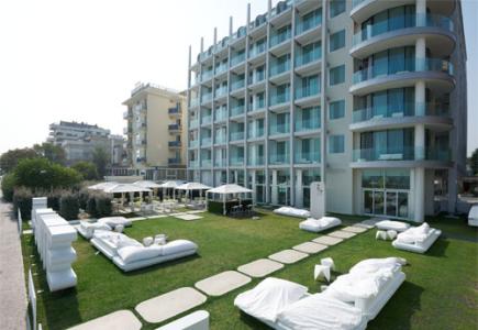 Hôtel moderne avec jardin et espace détente extérieur.