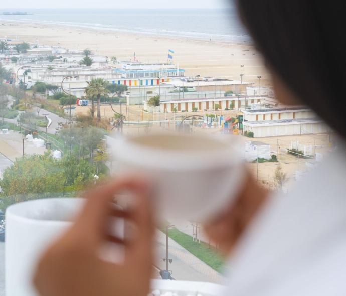 Vista sul mare con una tazza di caffè in mano.