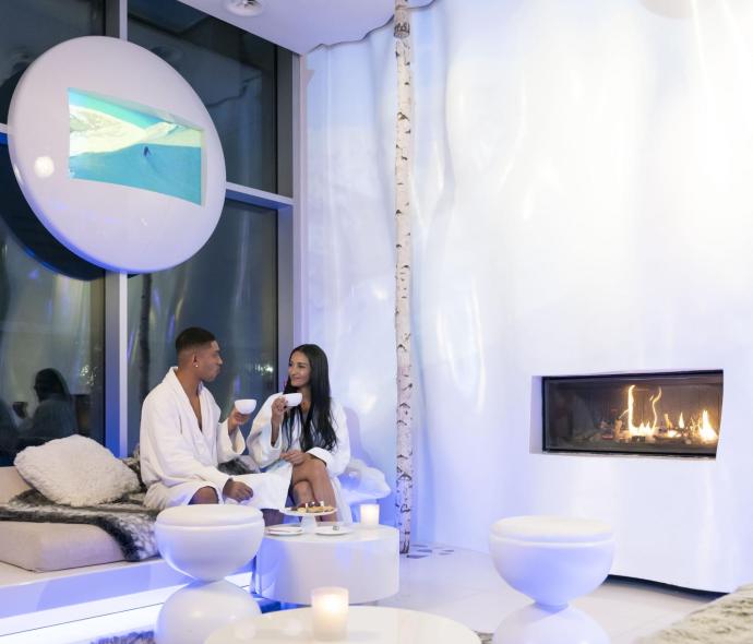 Relaxed couple in modern spa with fireplace.