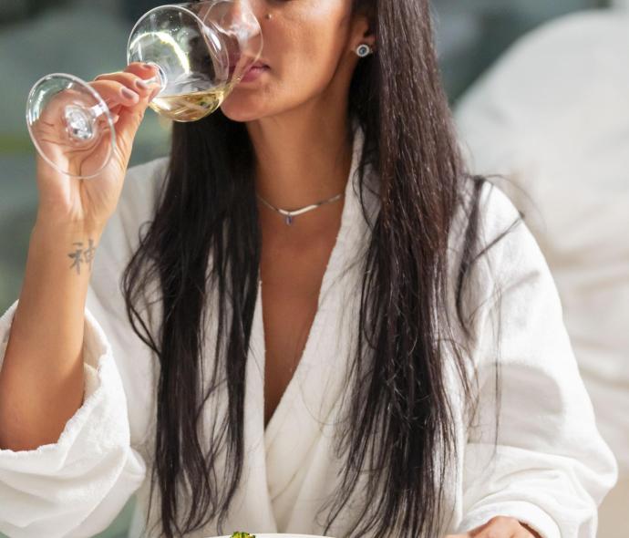 Femme buvant du vin avec plat élégant.